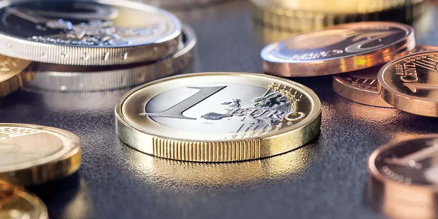Eine 1-Euro-Münze umringt von anderen Euro-Nominalen